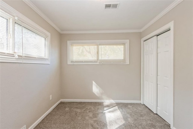 unfurnished bedroom featuring light colored carpet and crown molding