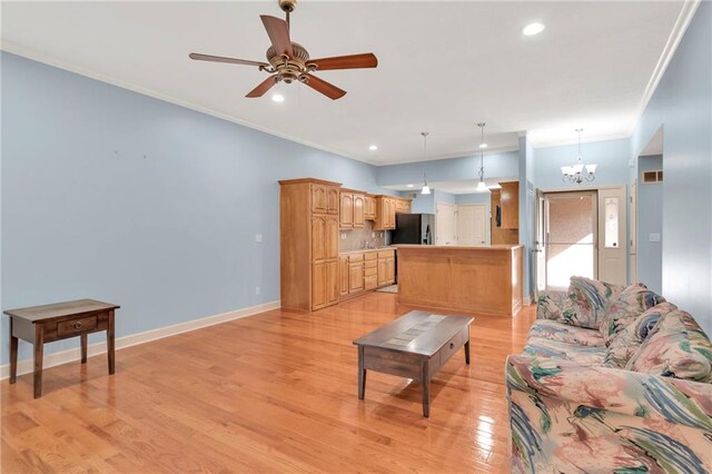 living room with crown molding, ceiling fan with notable chandelier, and light wood-type flooring