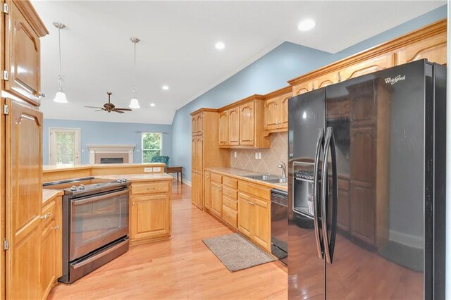 kitchen with lofted ceiling, decorative backsplash, black appliances, decorative light fixtures, and light hardwood / wood-style floors