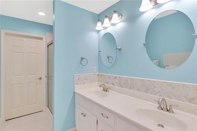 bathroom featuring vanity, an enclosed shower, and tile patterned flooring