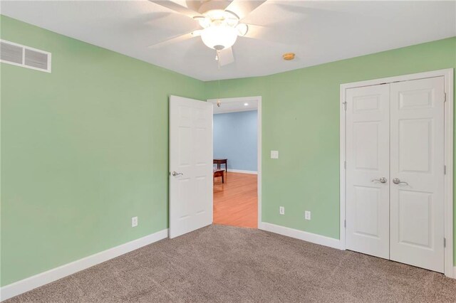 unfurnished bedroom with a closet, carpet flooring, and ceiling fan