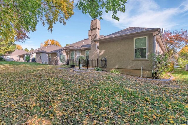 rear view of property featuring a lawn