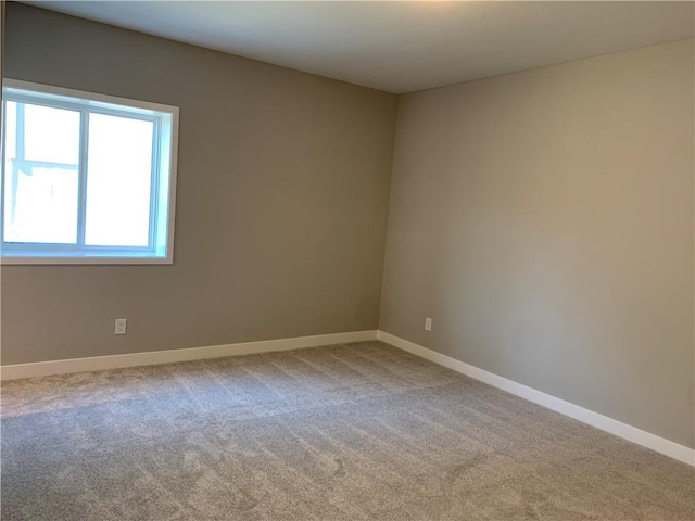 unfurnished room with carpet and baseboards