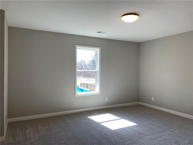 spare room featuring visible vents, baseboards, and carpet