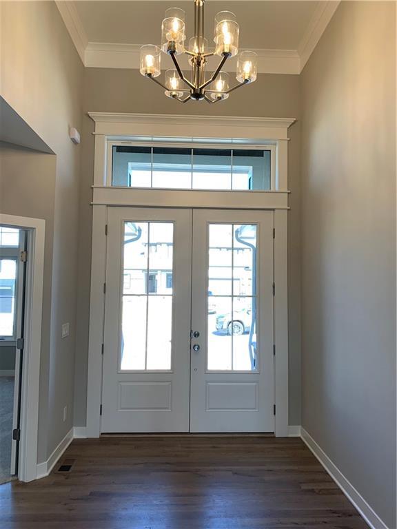 entryway with plenty of natural light and ornamental molding