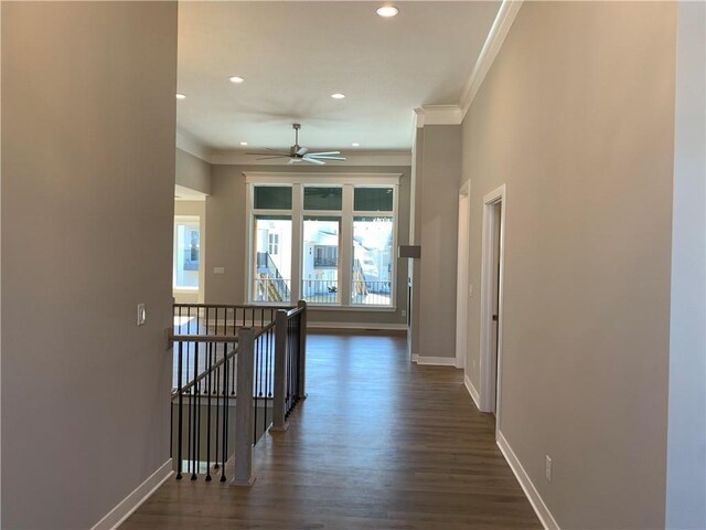 hall featuring baseboards, an upstairs landing, dark wood-style flooring, and ornamental molding