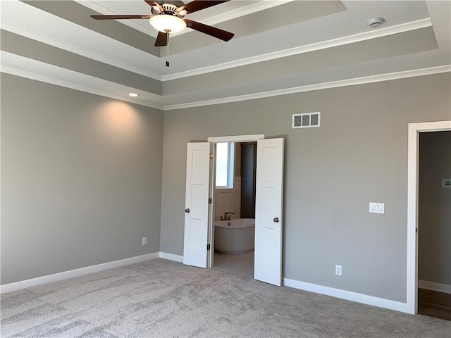 unfurnished bedroom featuring a raised ceiling, baseboards, visible vents, and ornamental molding