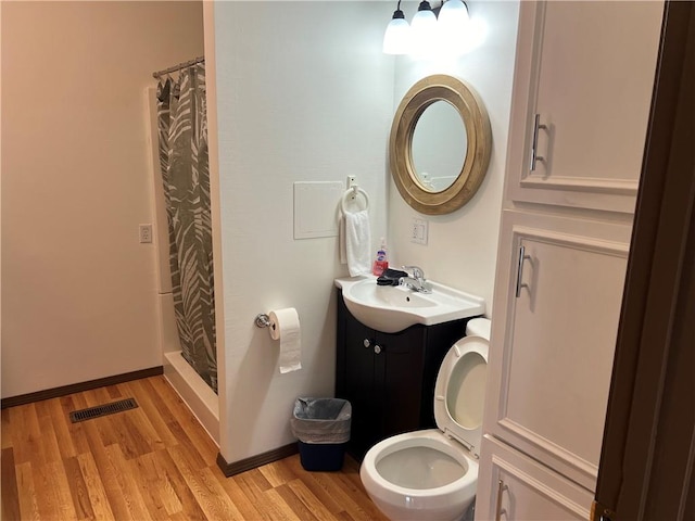 bathroom featuring vanity, toilet, hardwood / wood-style flooring, and a shower with curtain