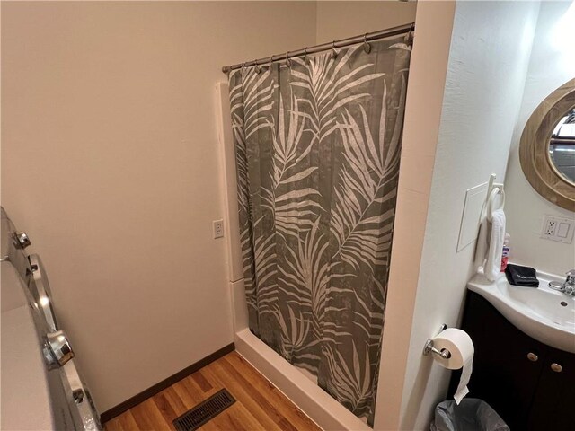 bathroom featuring vanity, hardwood / wood-style flooring, and walk in shower