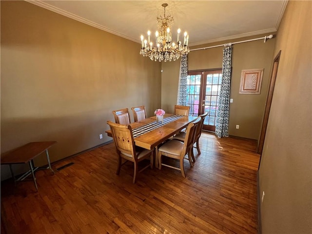 dining space with ornamental molding, a chandelier, and dark hardwood / wood-style flooring