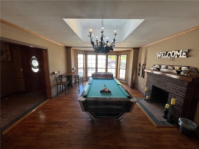 recreation room featuring pool table, dark hardwood / wood-style floors, a tray ceiling, and a fireplace