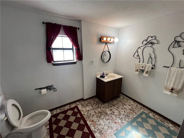 bathroom featuring toilet, a textured ceiling, and vanity