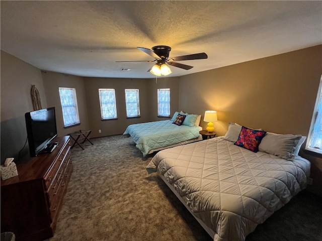 bedroom featuring ceiling fan, carpet flooring, and a textured ceiling