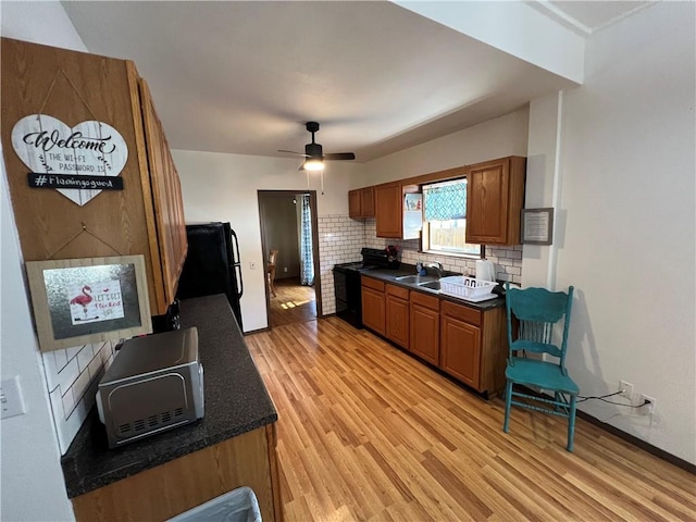 kitchen featuring black appliances, tasteful backsplash, light wood-type flooring, and ceiling fan