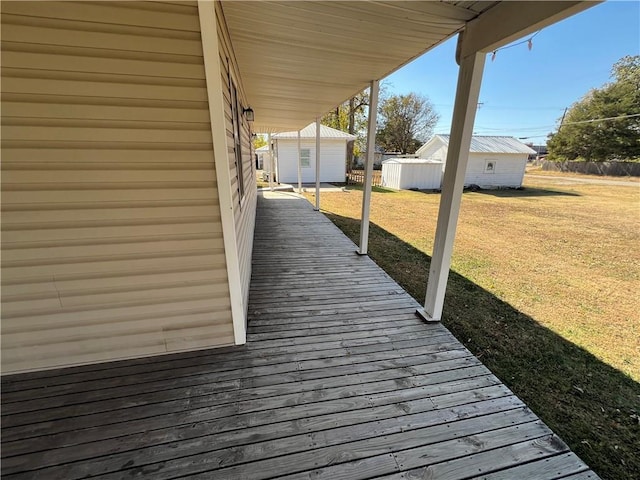 wooden deck featuring a yard and a storage unit