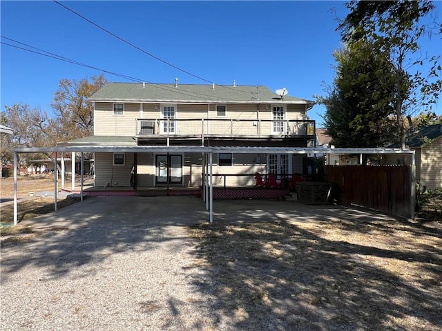 rear view of property featuring a balcony and a carport