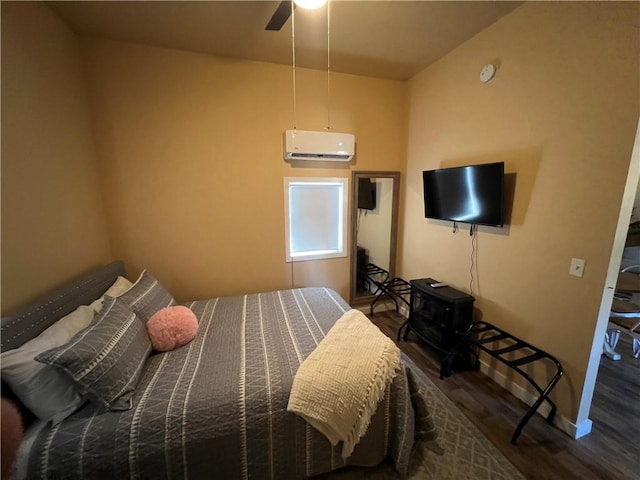 bedroom featuring ceiling fan, wood-type flooring, and a wall unit AC