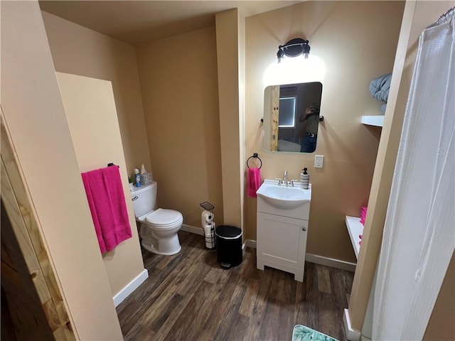 bathroom featuring vanity, wood-type flooring, and toilet