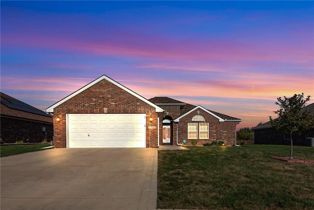 ranch-style house featuring a yard and a garage