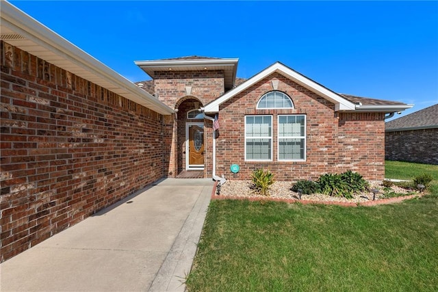 property entrance featuring a lawn