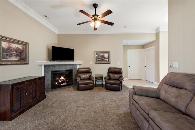 living room featuring ceiling fan, light colored carpet, ornamental molding, and a fireplace