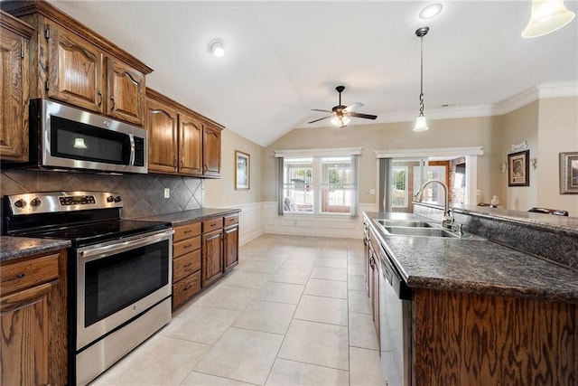 kitchen with a kitchen island with sink, hanging light fixtures, sink, vaulted ceiling, and appliances with stainless steel finishes