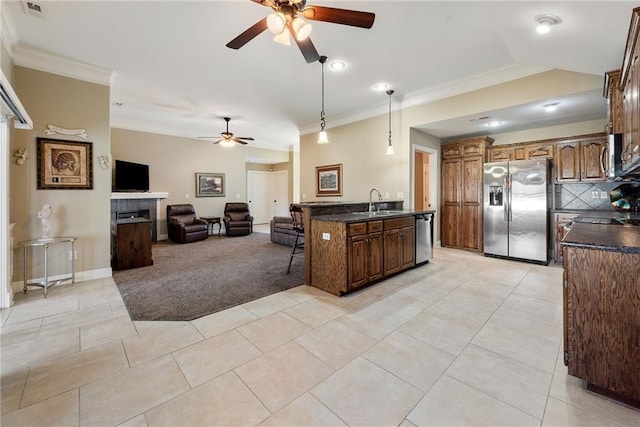 kitchen featuring pendant lighting, sink, ceiling fan, ornamental molding, and stainless steel appliances