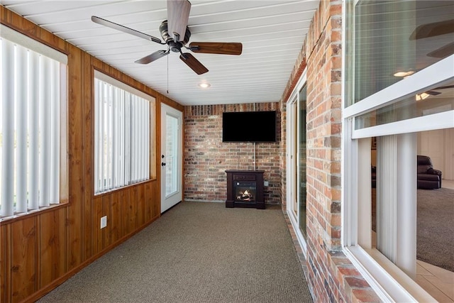 unfurnished sunroom with ceiling fan and a healthy amount of sunlight