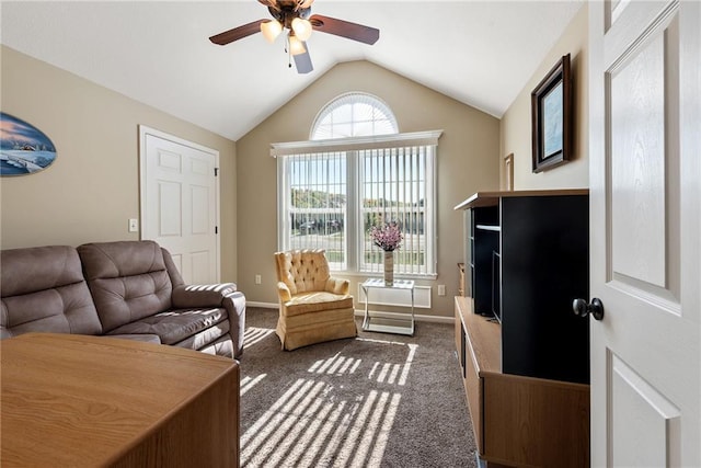 interior space featuring ceiling fan, dark carpet, and vaulted ceiling