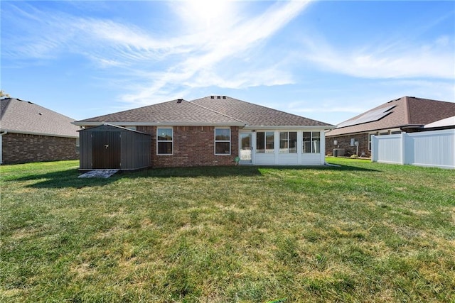 rear view of house with a yard and a storage unit