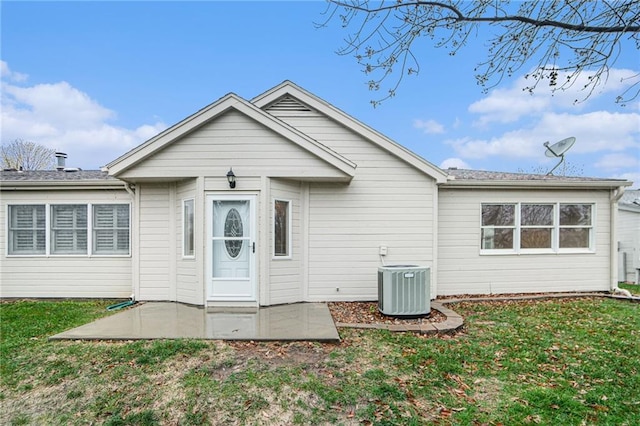 rear view of house featuring central air condition unit, a patio area, and a lawn