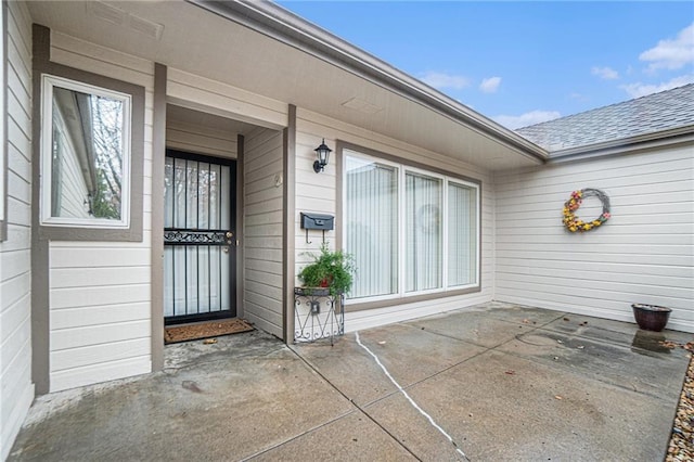 view of exterior entry with a patio area