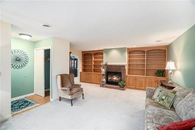 carpeted living room with a brick fireplace