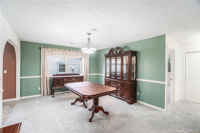 carpeted dining space featuring a textured ceiling