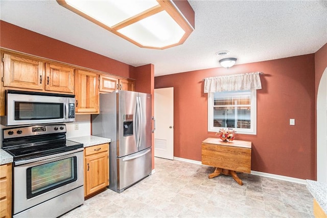 kitchen featuring a textured ceiling and appliances with stainless steel finishes