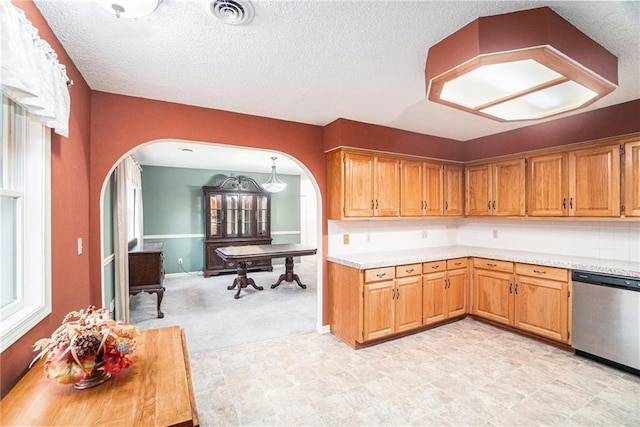 kitchen with a wealth of natural light, dishwasher, and a textured ceiling