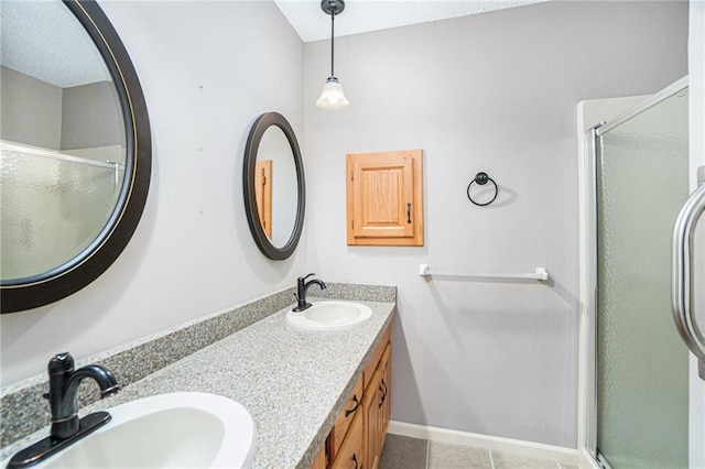 bathroom with tile patterned flooring, vanity, and walk in shower