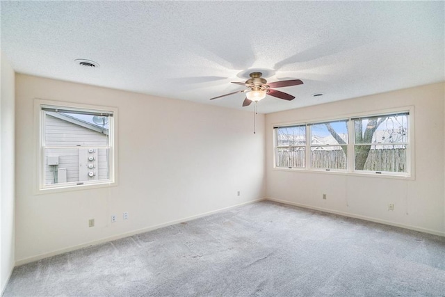 carpeted spare room featuring ceiling fan and a textured ceiling