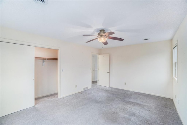 unfurnished bedroom featuring ceiling fan, a closet, and light carpet