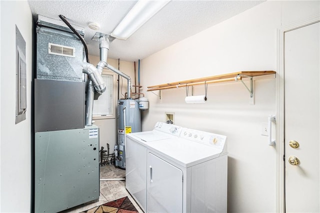 laundry room with heating unit, gas water heater, a textured ceiling, and washing machine and clothes dryer