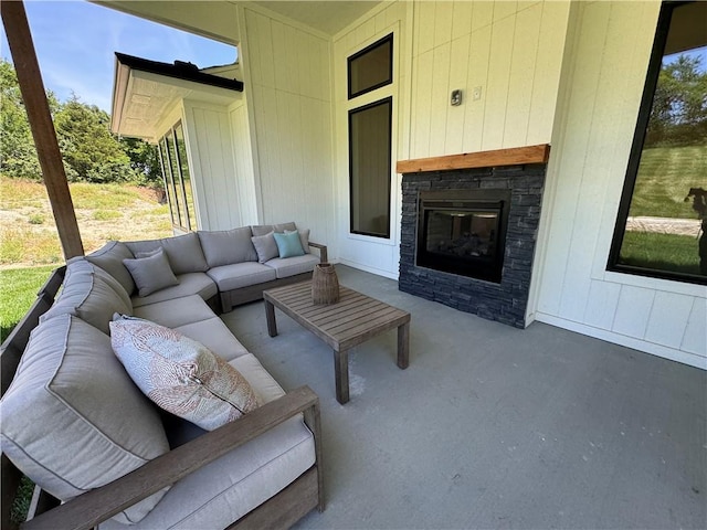 exterior space featuring concrete flooring, wood walls, and an outdoor stone fireplace