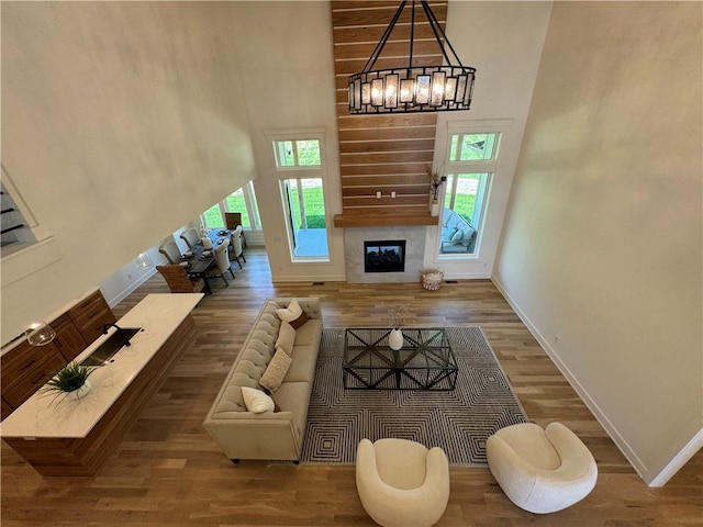 living room featuring wood-type flooring, a towering ceiling, and plenty of natural light