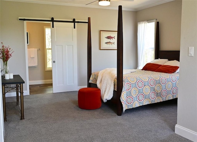 carpeted bedroom featuring a barn door, crown molding, and ceiling fan