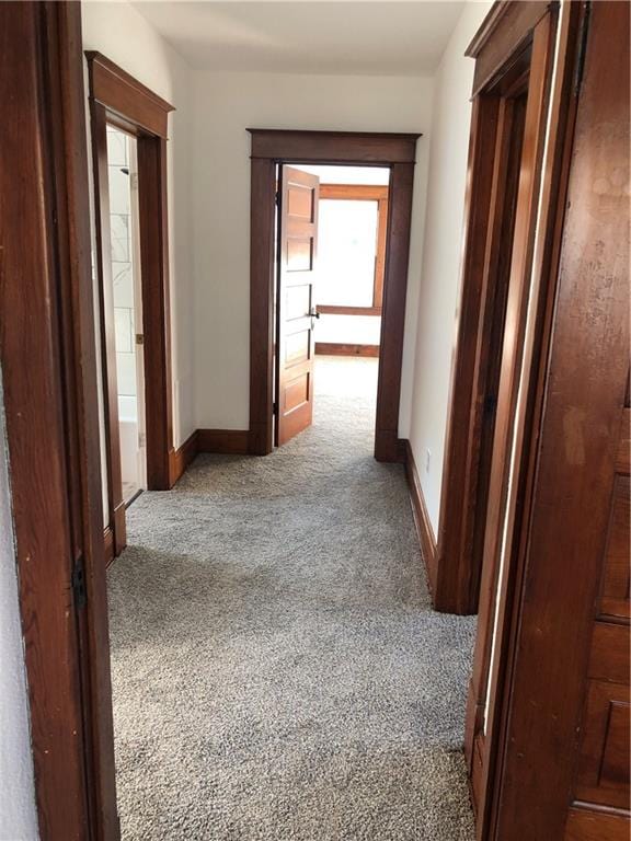 hallway featuring dark colored carpet