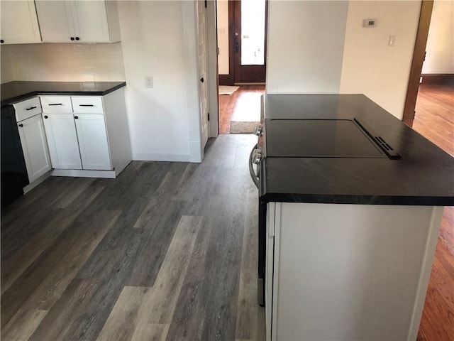 kitchen featuring dark wood-type flooring, backsplash, and white cabinets