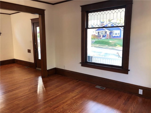 spare room with wood-type flooring and ornamental molding