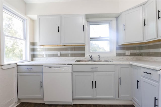 kitchen featuring dishwasher, dark hardwood / wood-style floors, sink, white cabinets, and tasteful backsplash