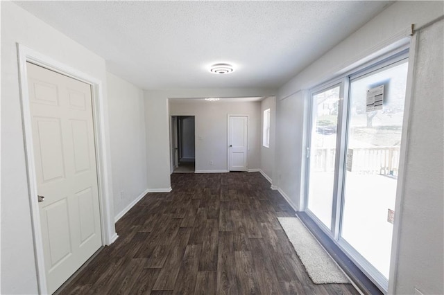 hall with dark hardwood / wood-style floors and a textured ceiling