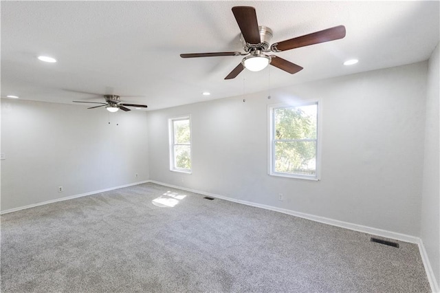 spare room with ceiling fan and carpet