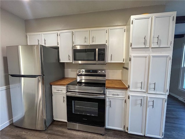 kitchen with dark hardwood / wood-style flooring, white cabinetry, stainless steel appliances, and wooden counters